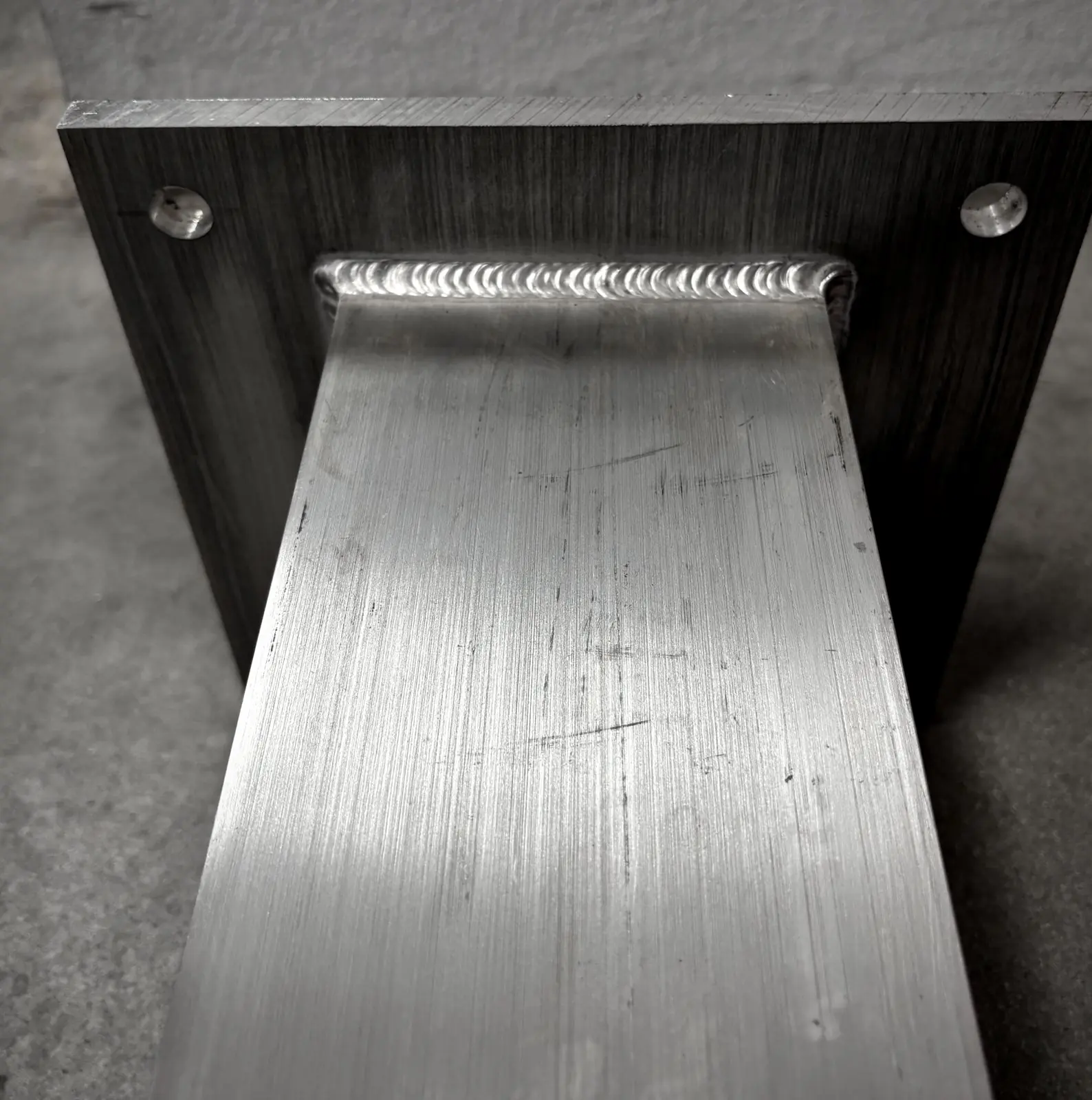 Close-up of an aluminum tube TIG welded to a base plate